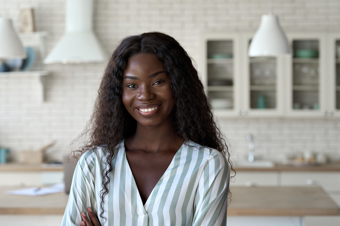 Headshot Portrait of Young Black Woman Looking at Camera Indoors.